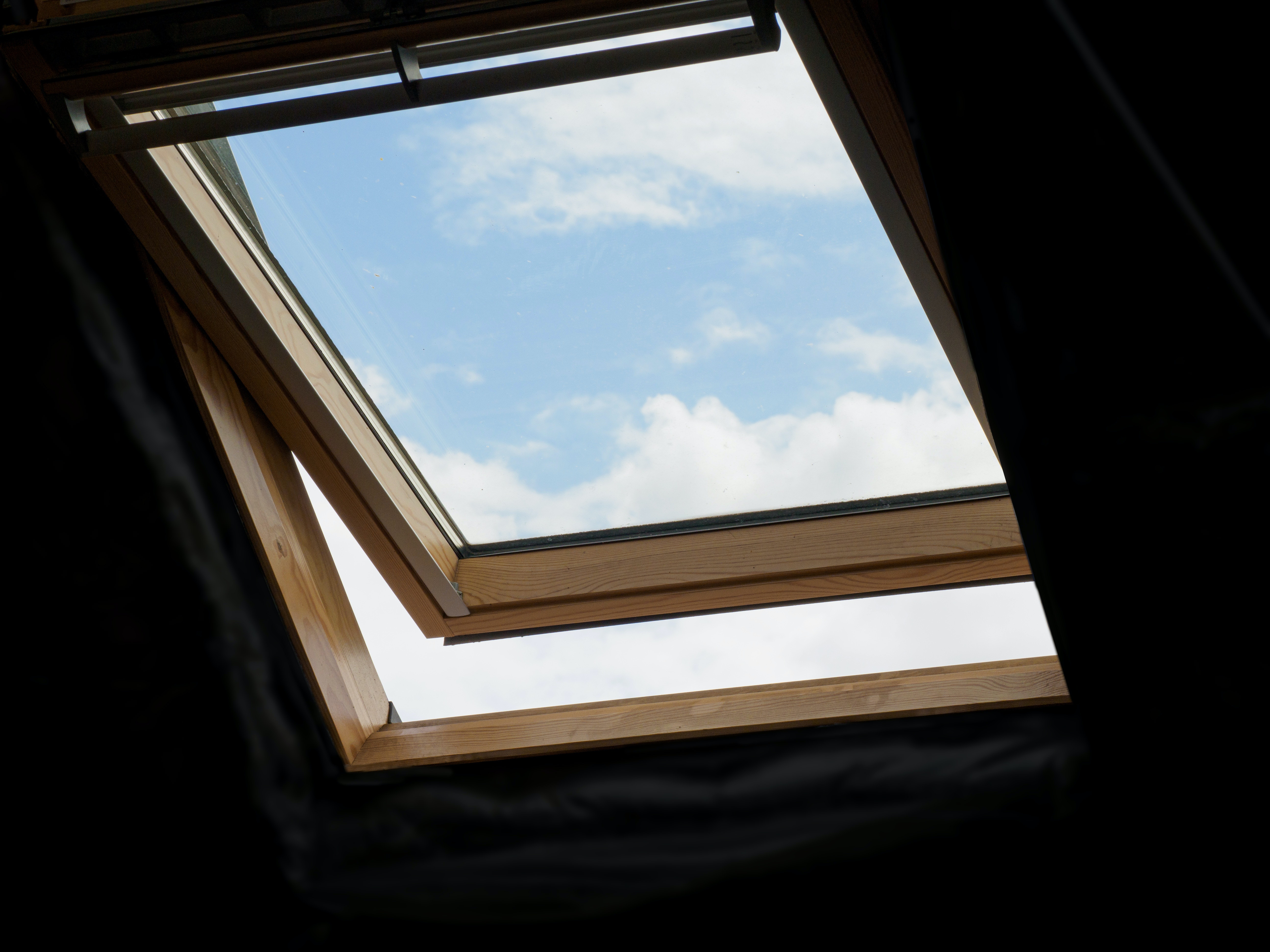 Široké střešní okno zabudované do šikmé střechy domu